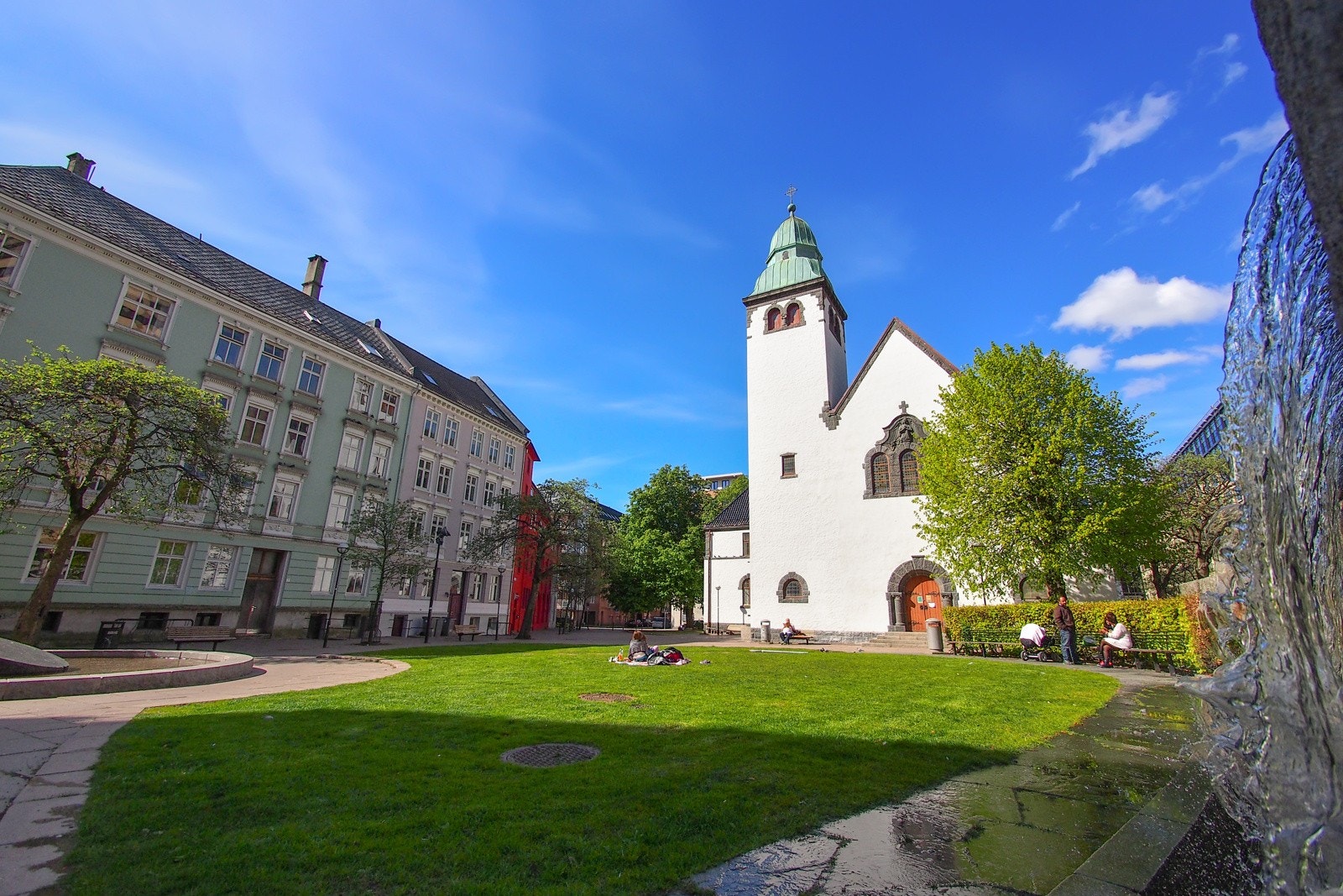 Koselige St. Jacobsplass rett ved bygget har gressplen, benker og vannfall. Galleribilde