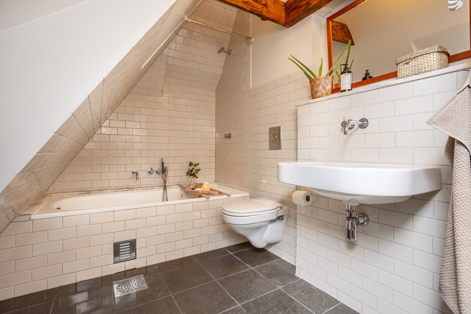 Badet på loftet er utstyrt med vegghengt wc, servant og dusj i innmurt badekar. Galleribilde
