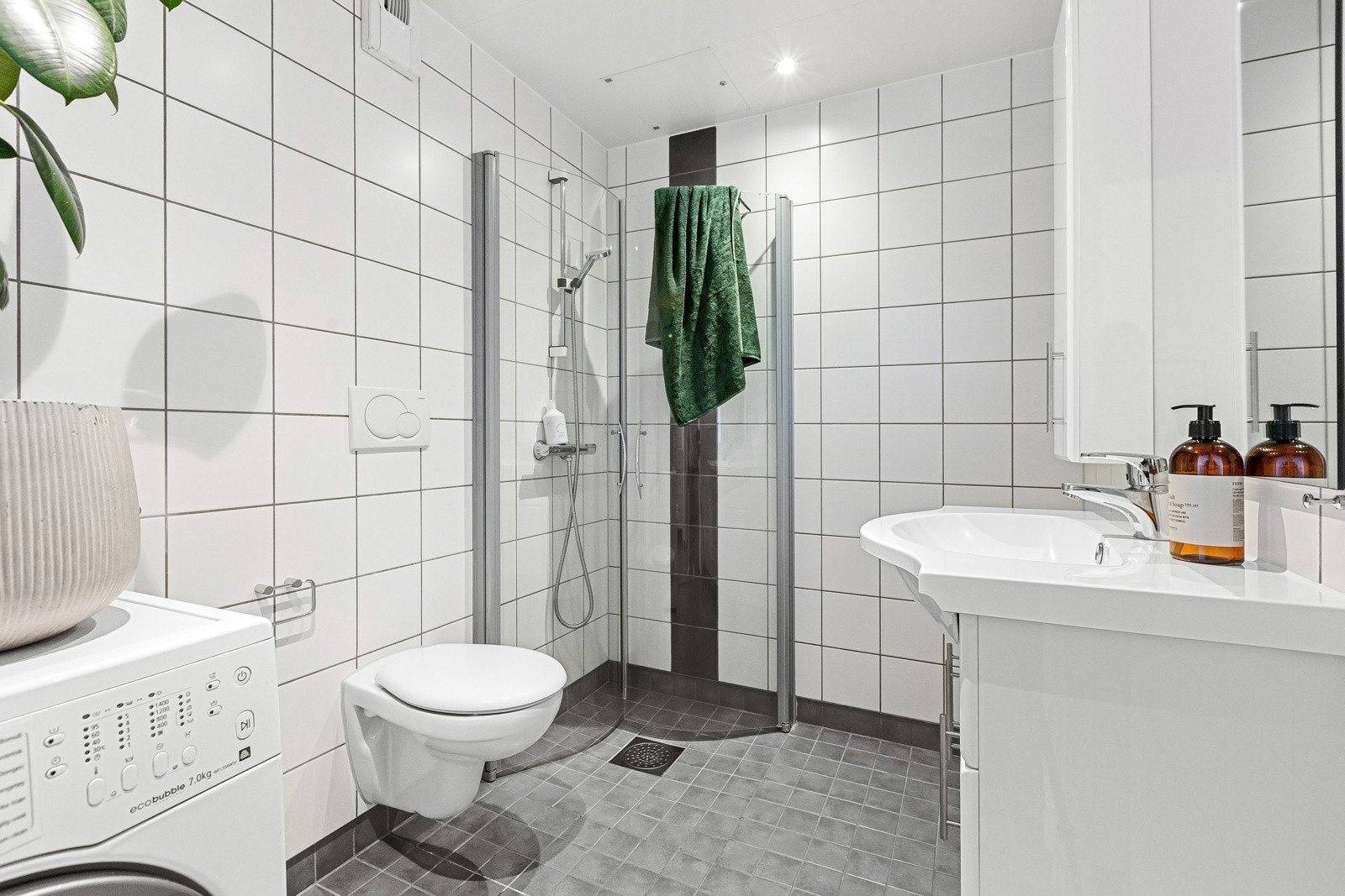 Stilrent og flislagt bad med gulvvarme og opplegg for vaskemaskin. Galleribilde