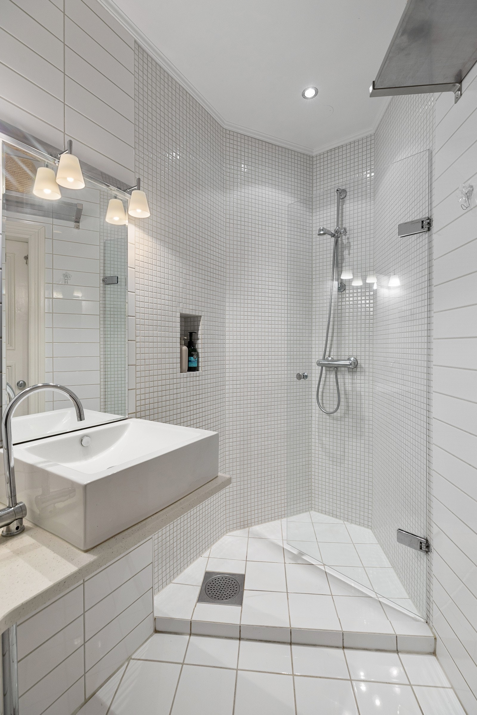 Badet fremstår som stilrent og tidløst med store fliser i tørr-sone, og mindre fliser i dusj Galleribilde