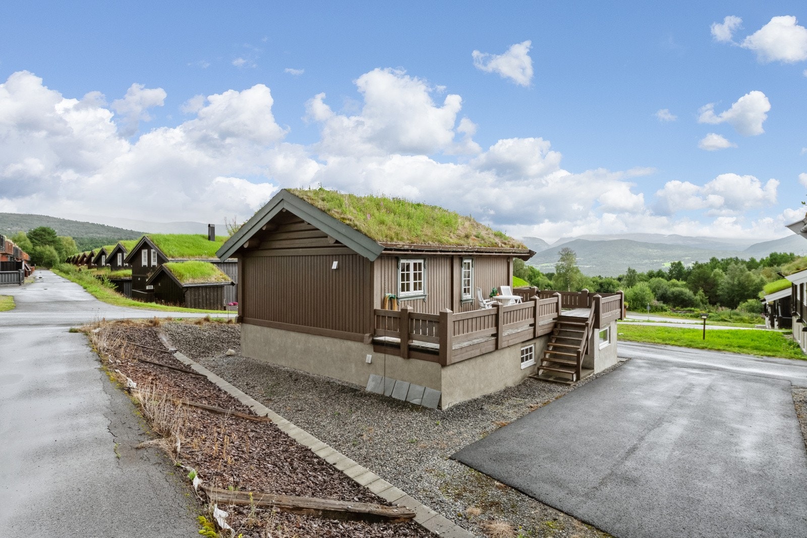 Stor parkeringsplass, med trapp opp til balkong der man kan nyte de rolige omgivelsene. Selger opplyser at parkeringsplassen også blir brøytet om vinteren. Galleribilde