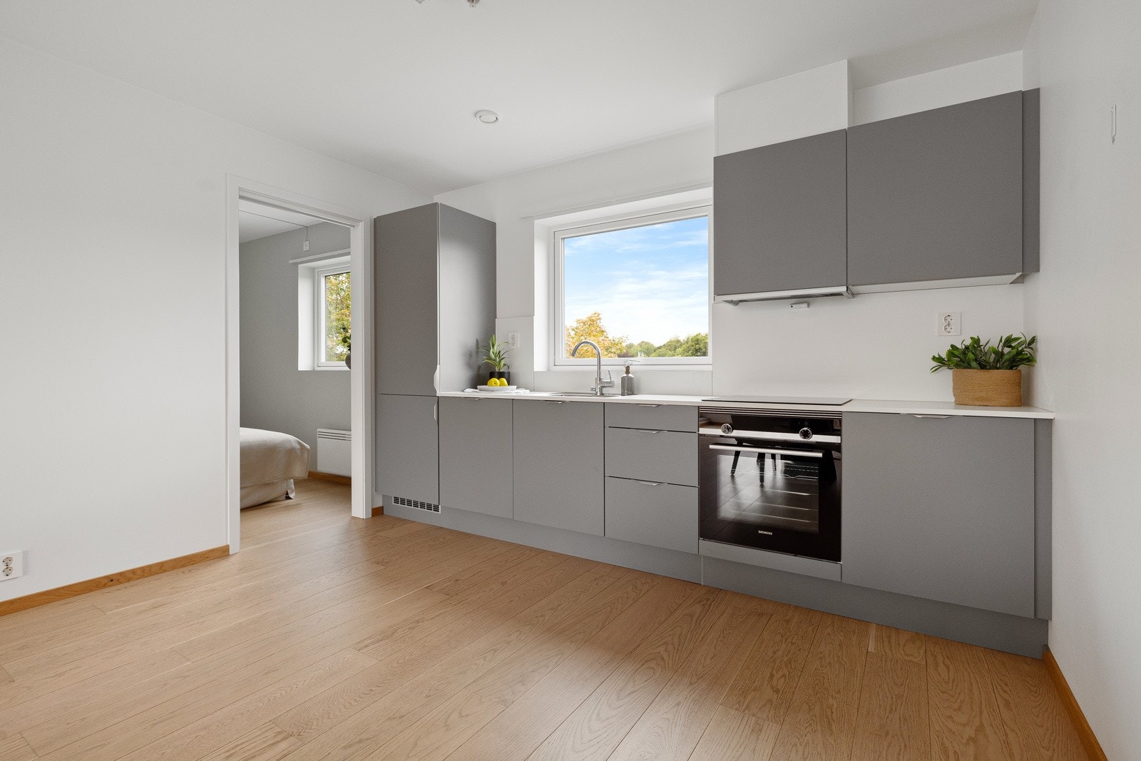 Tidsriktig glatt innredning fra HTH, soft close, laminat benkeplate med nedfelt stålkum og induksjonstopp, integrert komfyr, oppvaskmaskin, kjøl/frys, bereder. Galleribilde