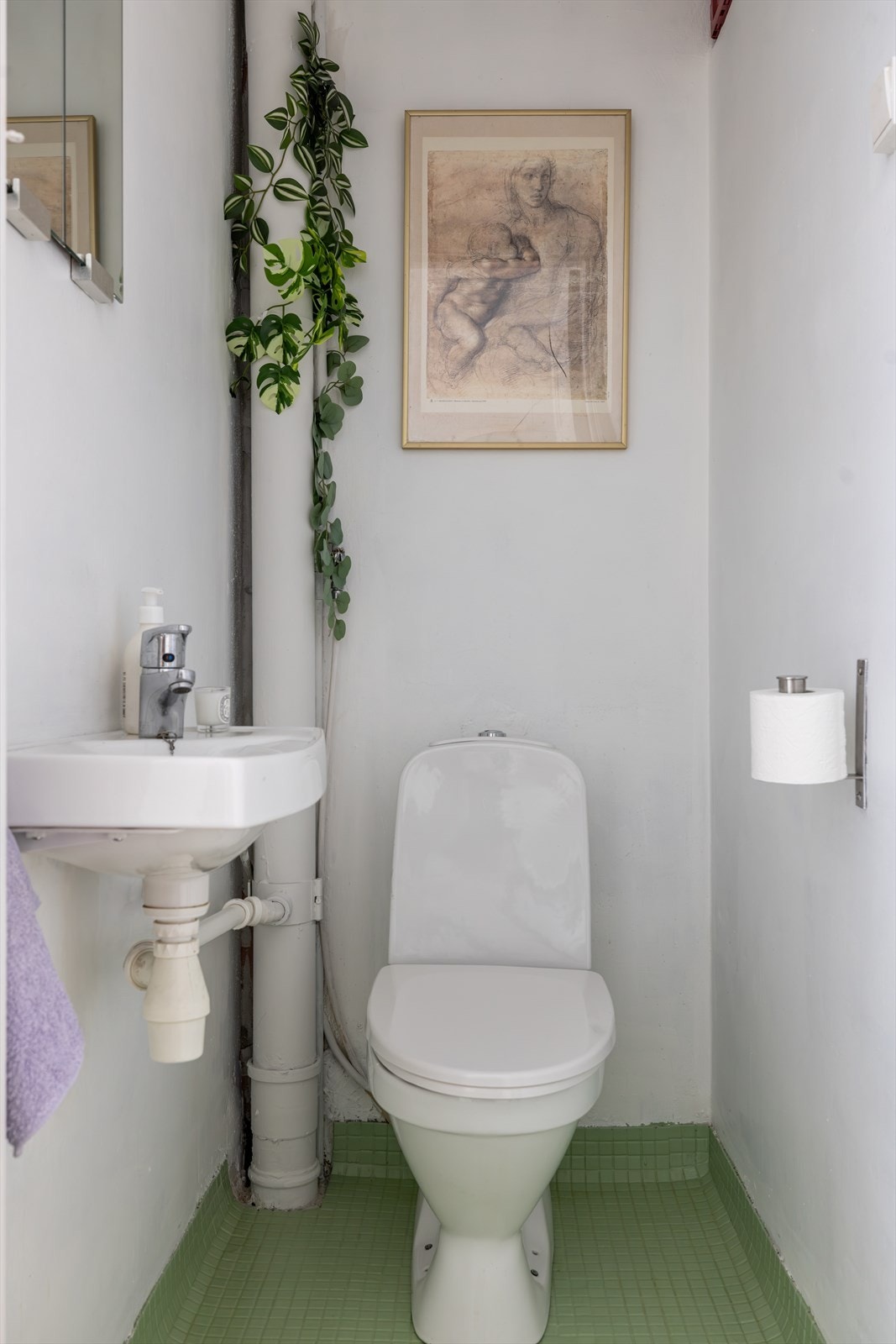 Separat toalettrom med gulvmontert toalett, servant og speil. Galleribilde