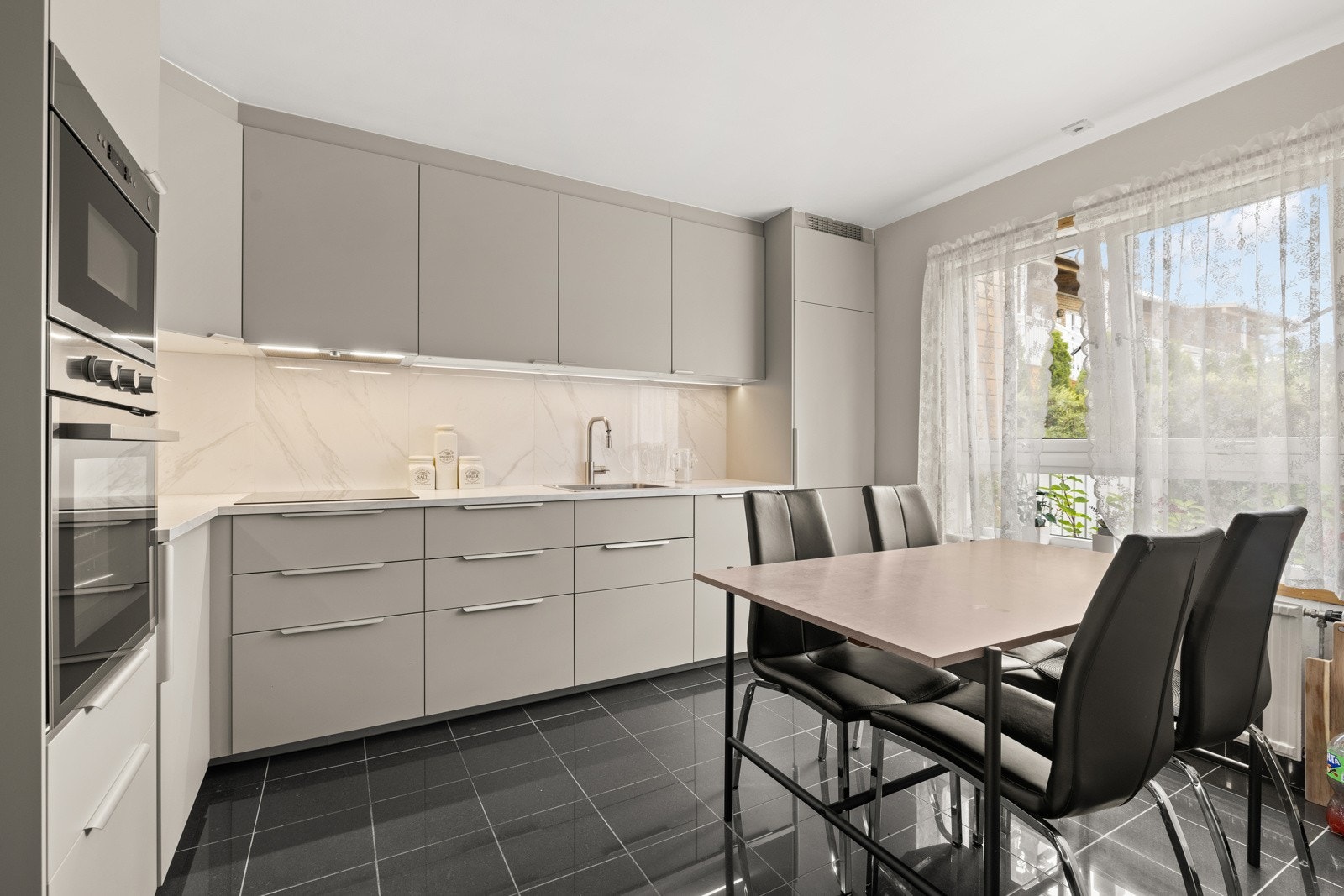 Boligen har et stilrent og moderne kjøkken Galleribilde