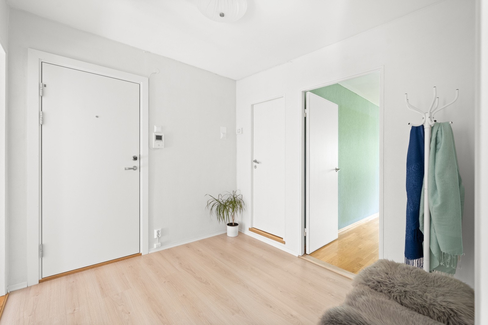 Her bor du fint til i gårdens 1.etasje med trappefri adkomst. Entréen er romslig med plass til å innrede med ulike oppbevaringsløsninger for yttertøy og sko Galleribilde