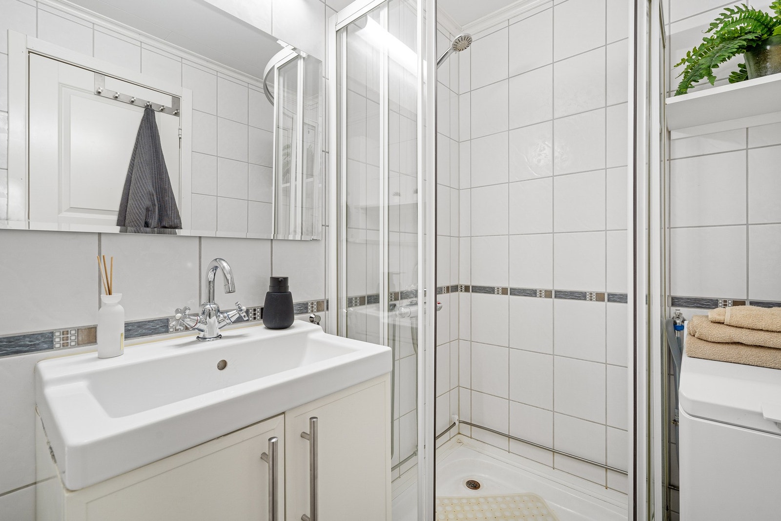 Badet er innredet med dusjkabinett og gulvmontert toalett. Galleribilde