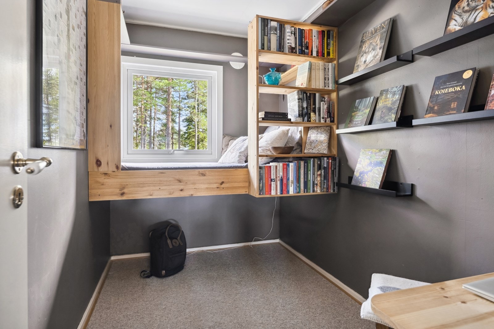 Soverom med bokhyller og vindu mot skogen. Galleribilde