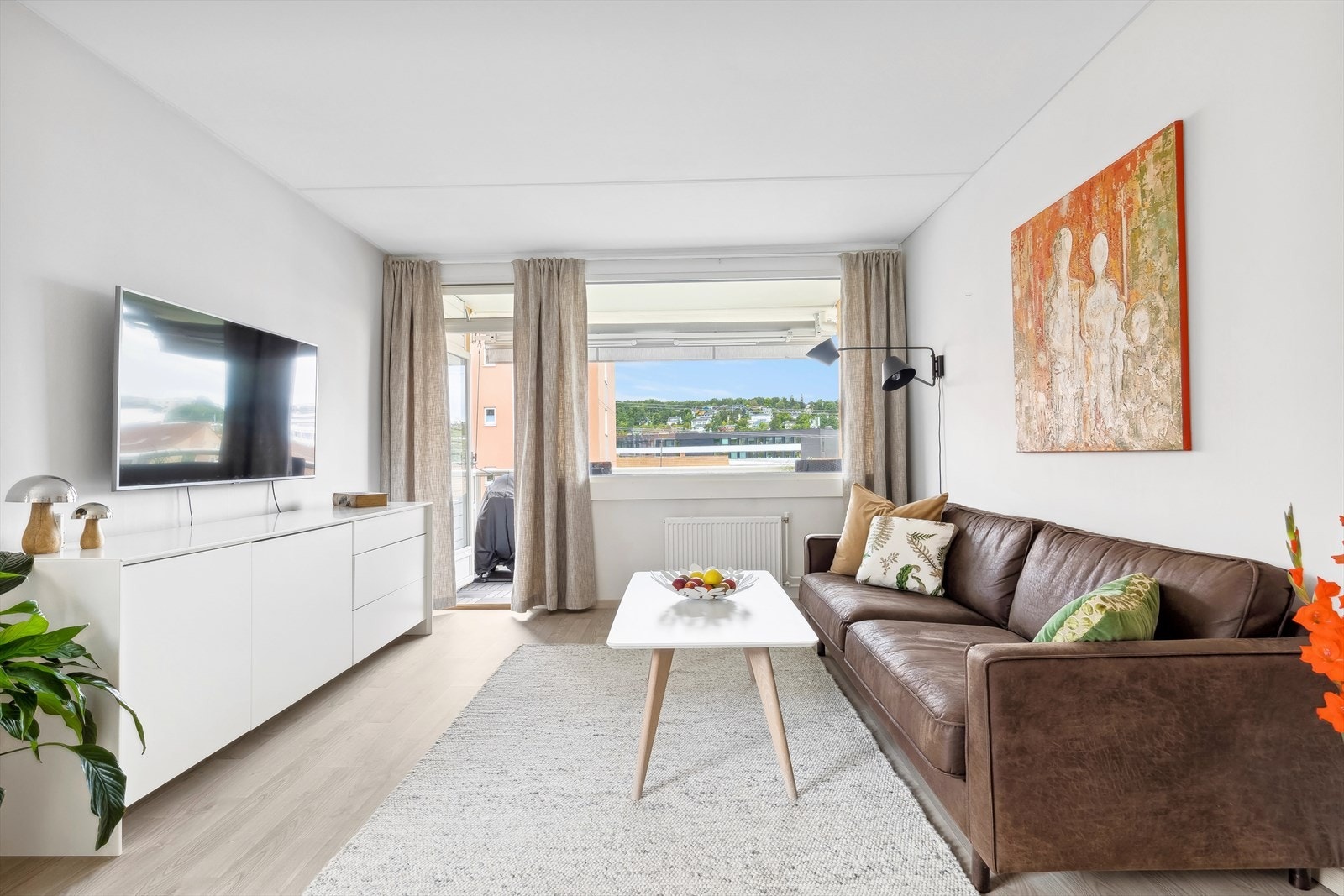 Den flotte stuen har store vindusflater, som sammen med balkongdør slipper inn godt med lys å skaper en luftig og fin atmosfære i rommet. Galleribilde