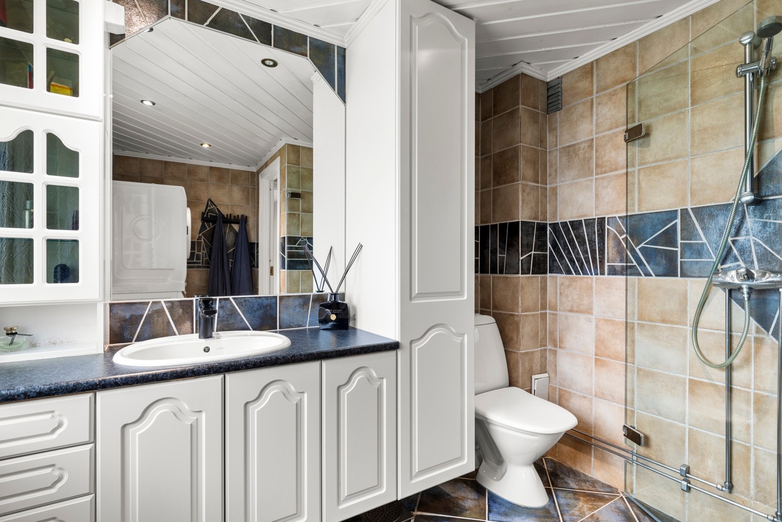 Flislagt bad med romslig skapinnredning. Galleribilde