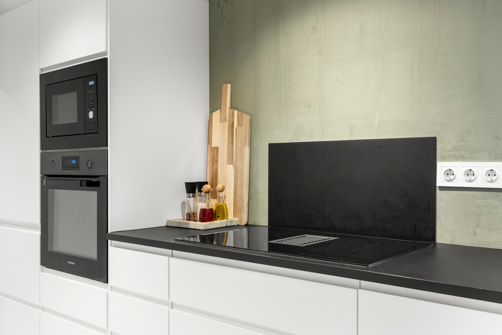 Nedfelt stikkontakter i benkeplater og stikkontakter samt sprutplater på vegg over kjøkkenbenk Galleribilde