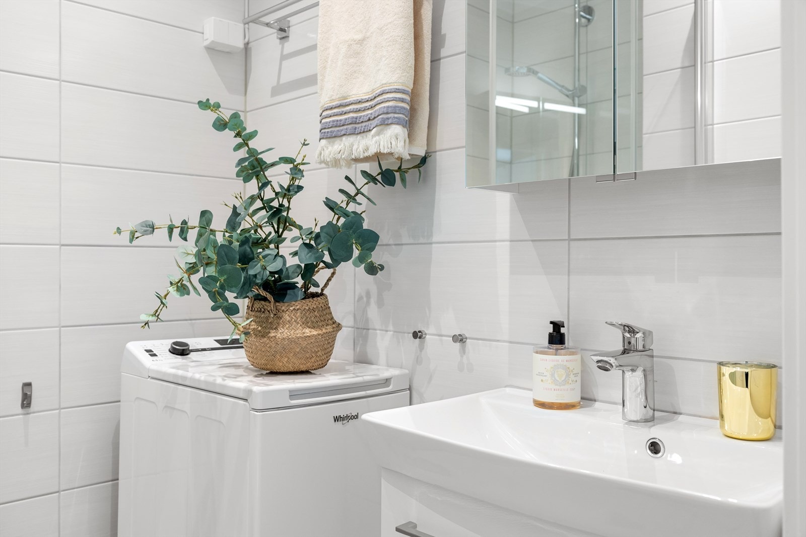 Badet er utstyrt med et servantskap med glatte fronter, heldekkende servant, speilskap med lysarmatur på veggen over servanten og veggmontert klosett. Galleribilde