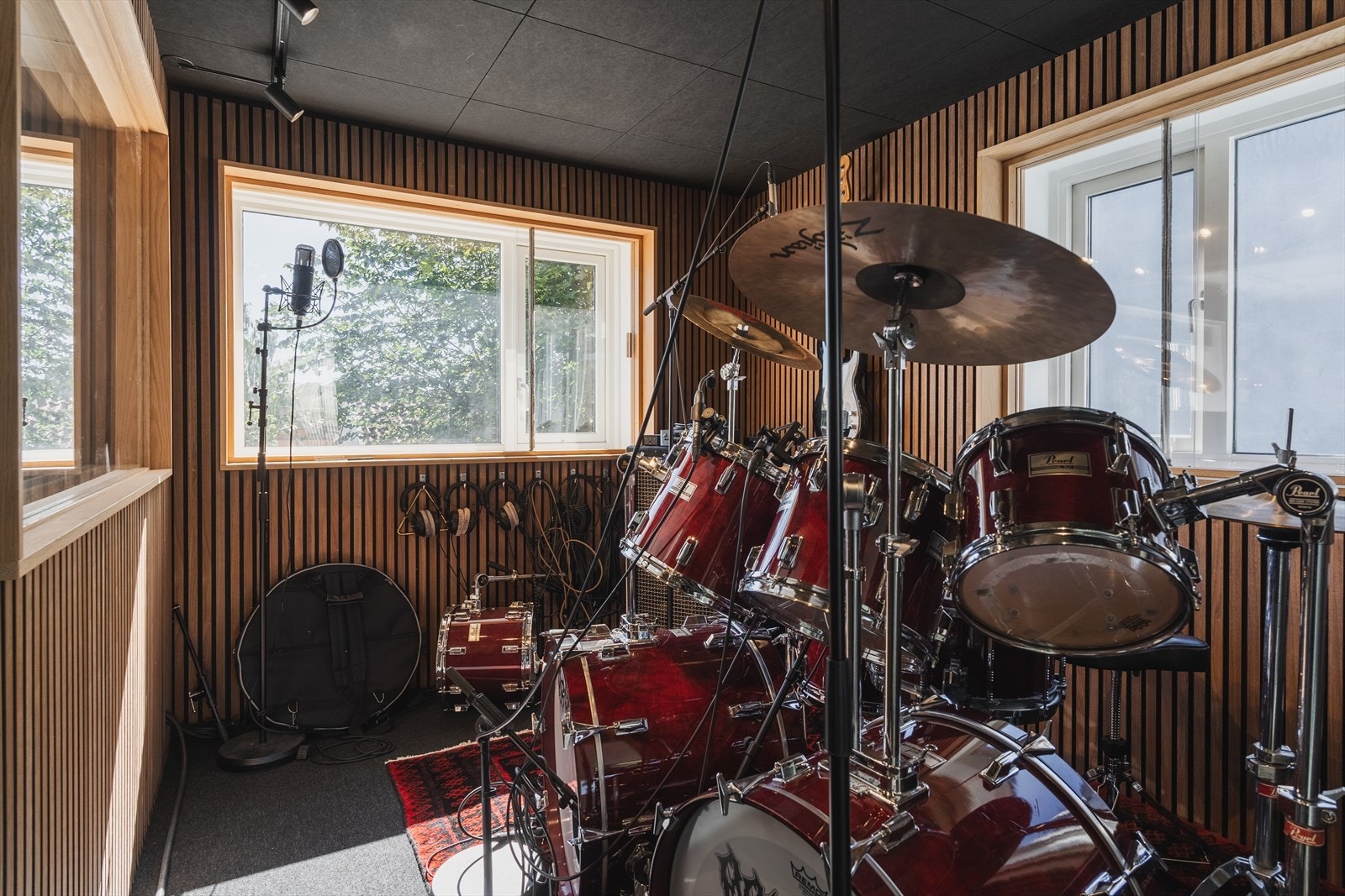 Eget musikkrom med moderne spileplater på vegg og mørke lydplanker i tak. Rommet er byggemeldt som soverom og kan tilbakestilles. Galleribilde