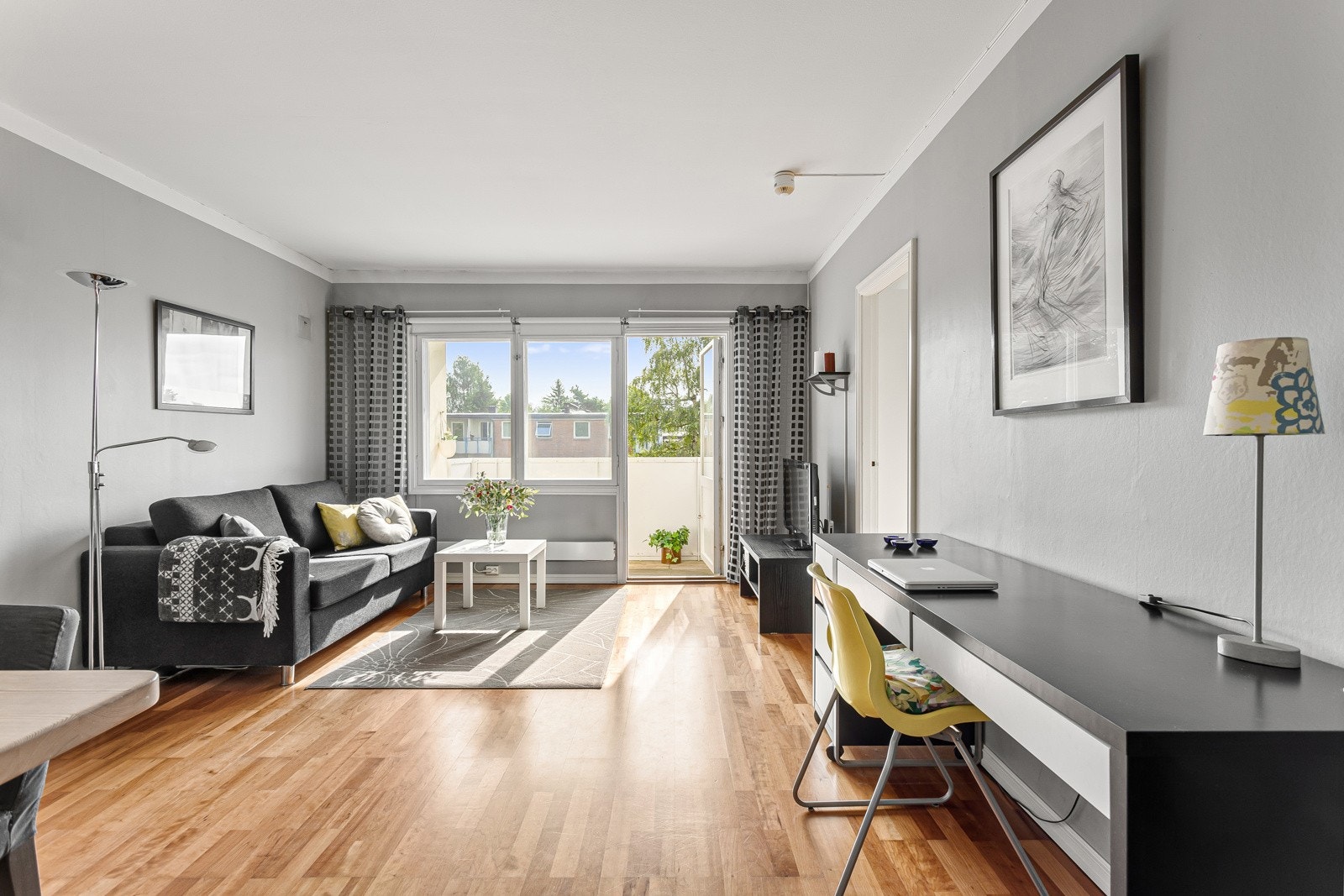 Trekker vi oss tilbake inn i leiligheten kommer du til en lys, romslig og lettmøblert stue. Galleribilde