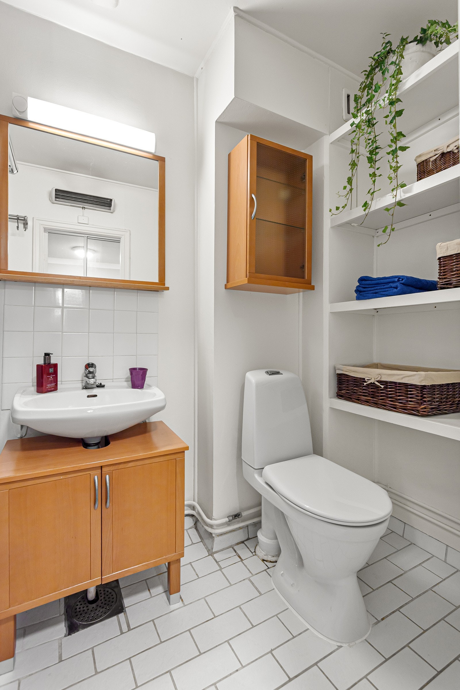 Baderomsinnredning med skuffer og servant, veggspeil med belysning over Galleribilde