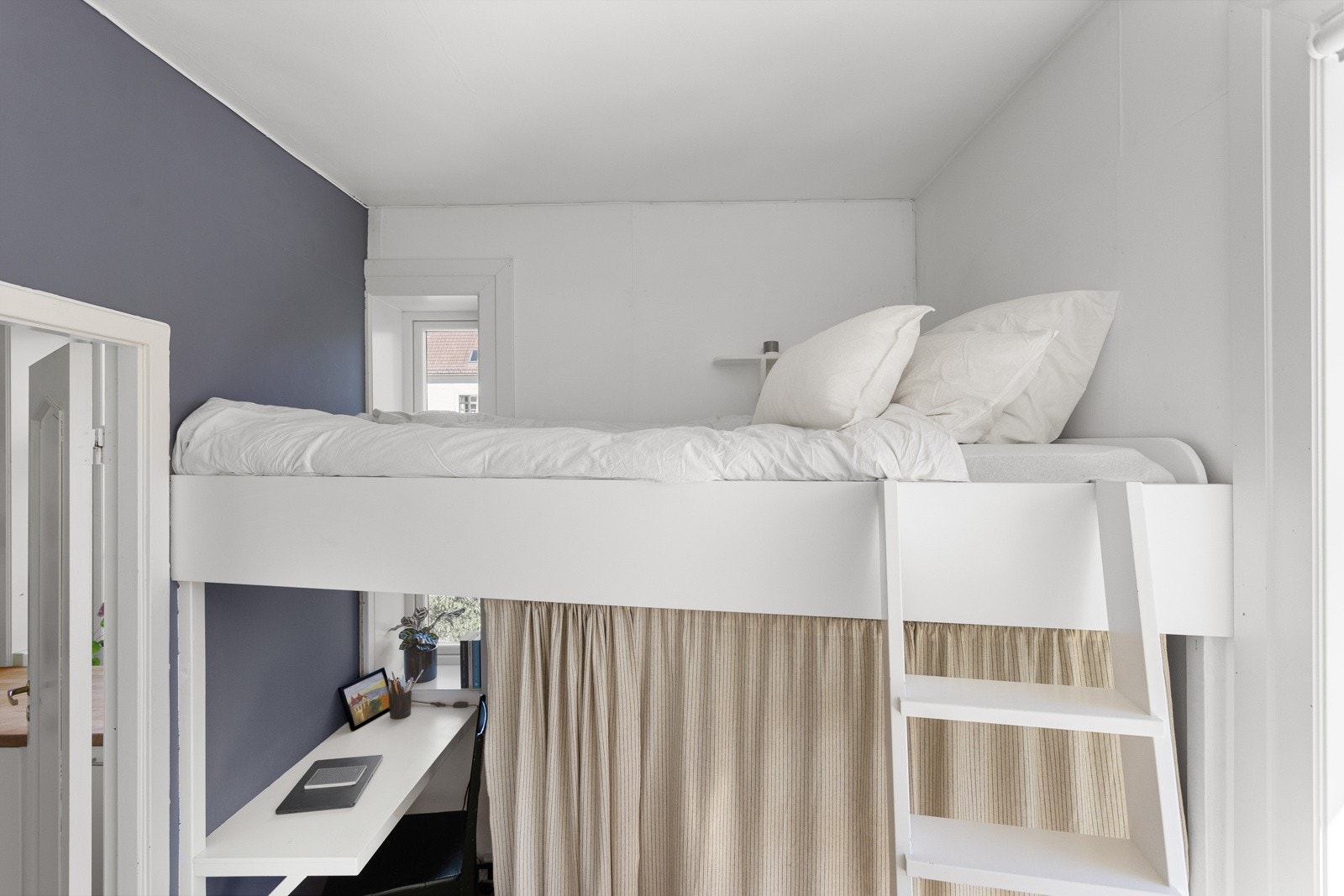 Soverommet har parkett på gulv og lysmalte overflater med en fin blå kontrastvegg. Galleribilde