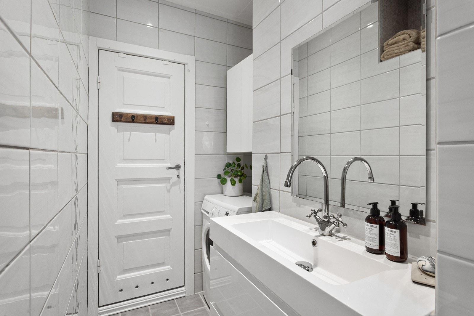 Praktisk nisje med plass og opplegg for vaskemaskin, samt oppbevaringsplass i skap over. Galleribilde