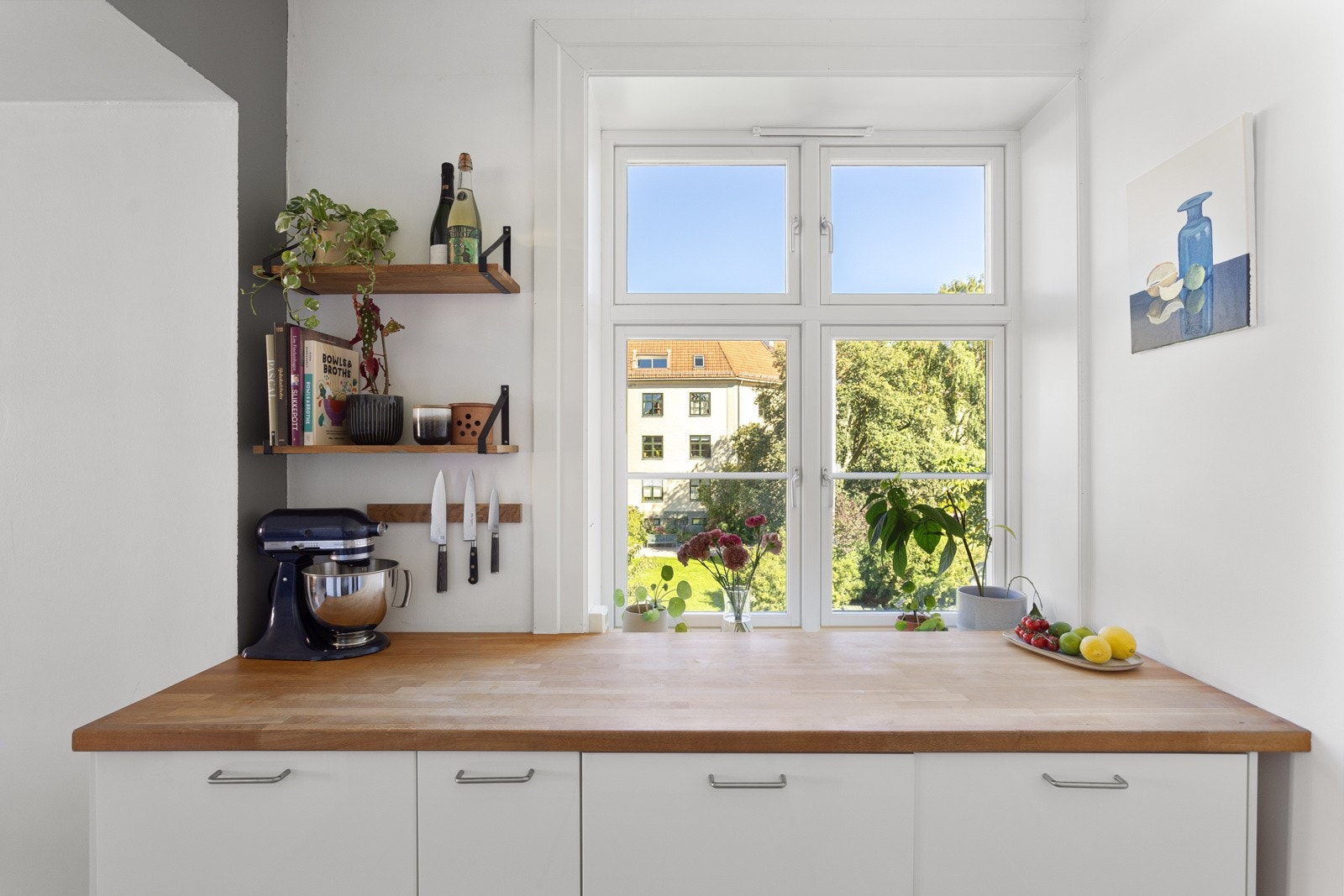 Innredningen har hvite glatte fronter og benkeplate av tre med nedsenket oppvaskkum. Galleribilde