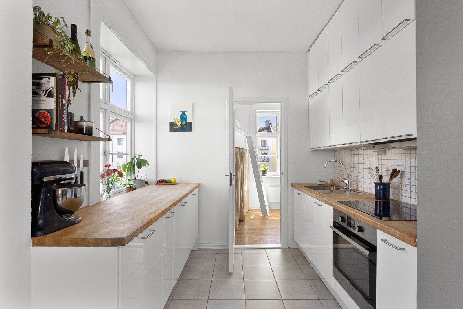 Kjøkkenet har god standard med flislagt gulv og lysmalte overflater med en mørk kontrastvegg. Galleribilde