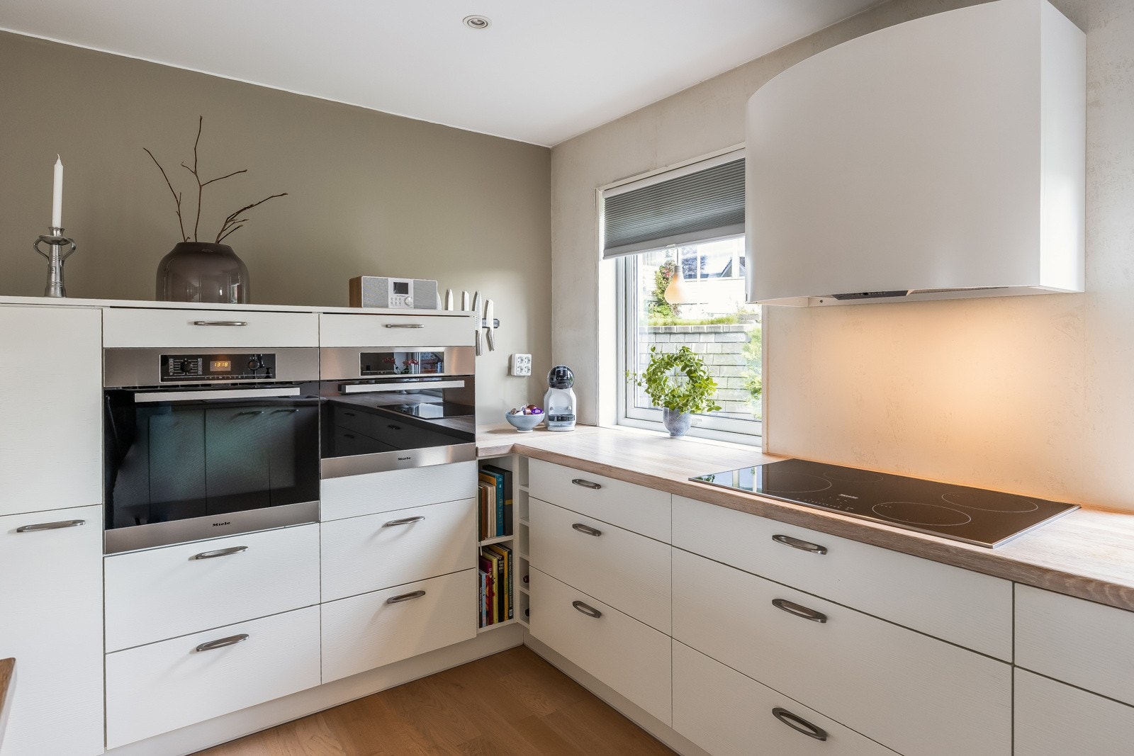 Innredningen har integrert oppvaskmaskin (ny 2022), 80 cm induksjon koketopp, kjøleskap og dampovn, alt fra Miele. Galleribilde