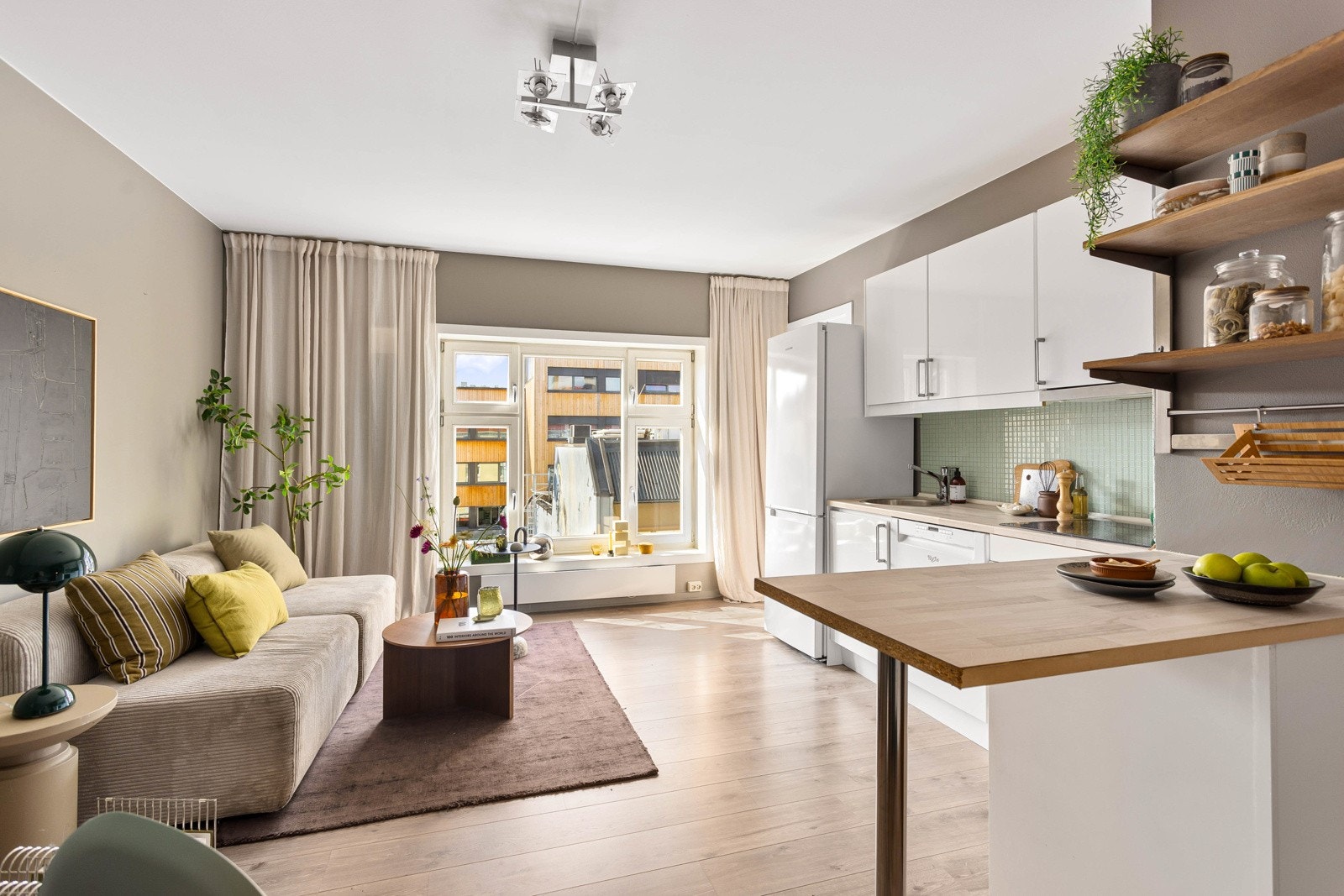 - Det store vinduet som strekker seg nesten fra gulv til tak, slipper inn rikelig med naturlig lys og gir rommet en lys og luftig atmosfære. - Galleribilde