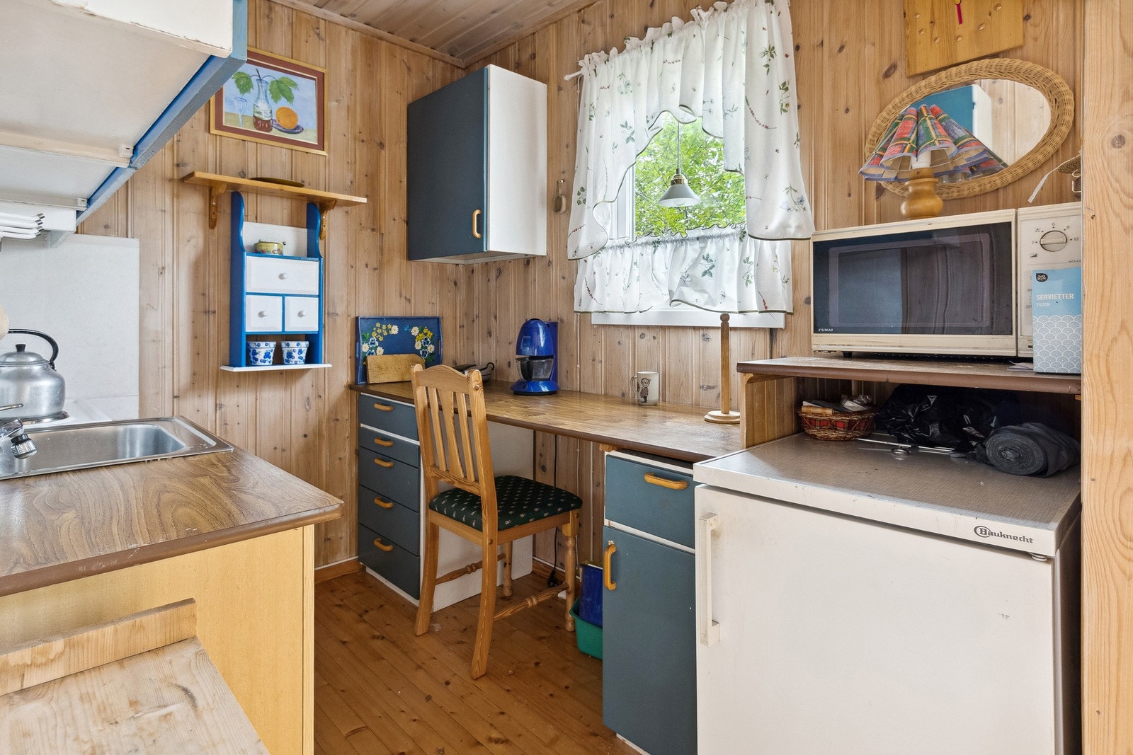 Koselig hyttekjøkken med spiseplass under vinduet. Galleribilde