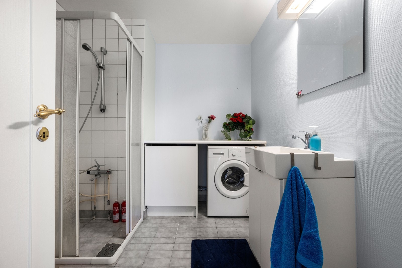 Badet har gulvvarme, opplegg for vaskemaskin og et dusjhjørne med veggmontert dusjarmatur Galleribilde