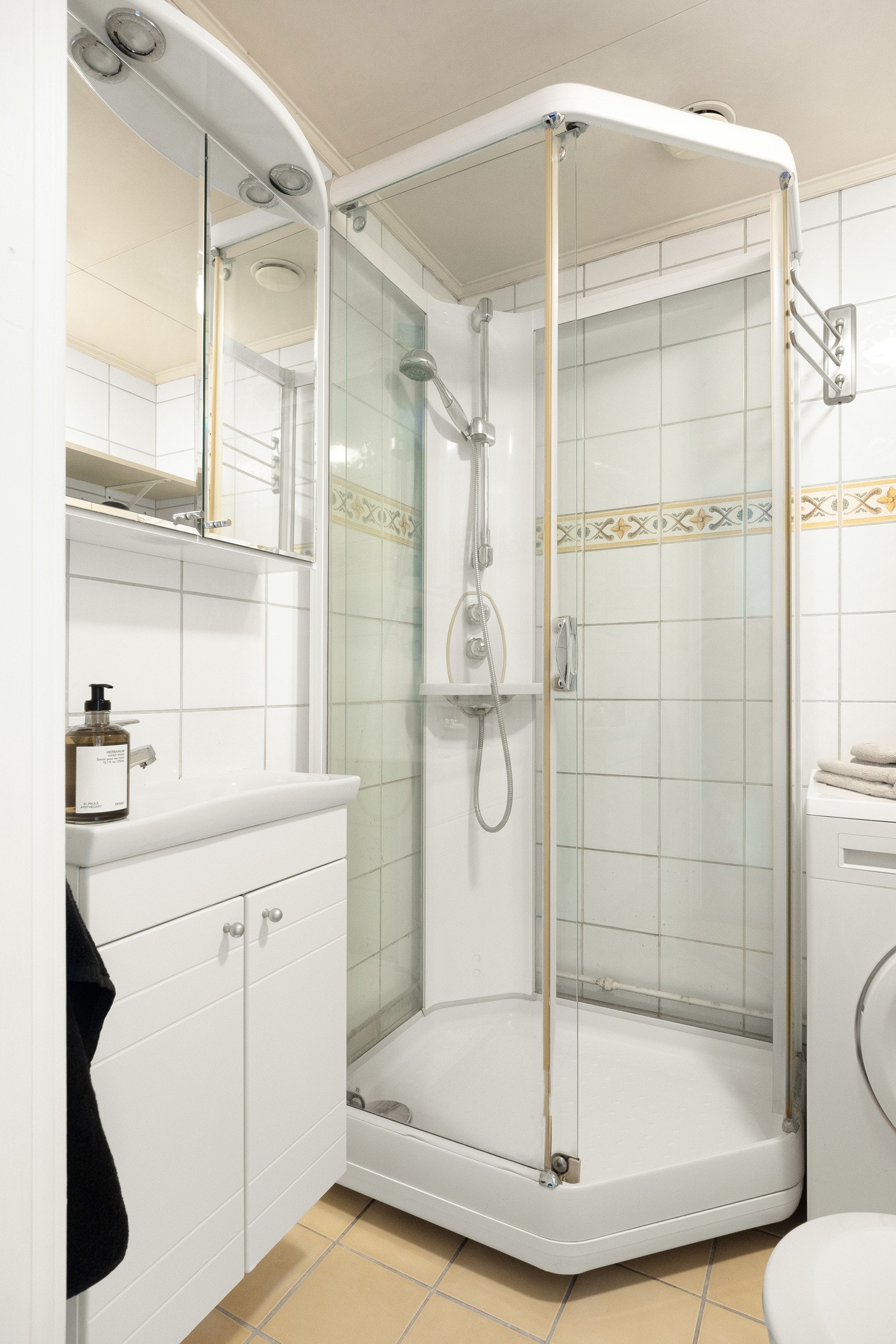 Badet er innredet med dusjkabinett, servant med skapinnredning, speilskap og toalett. Galleribilde