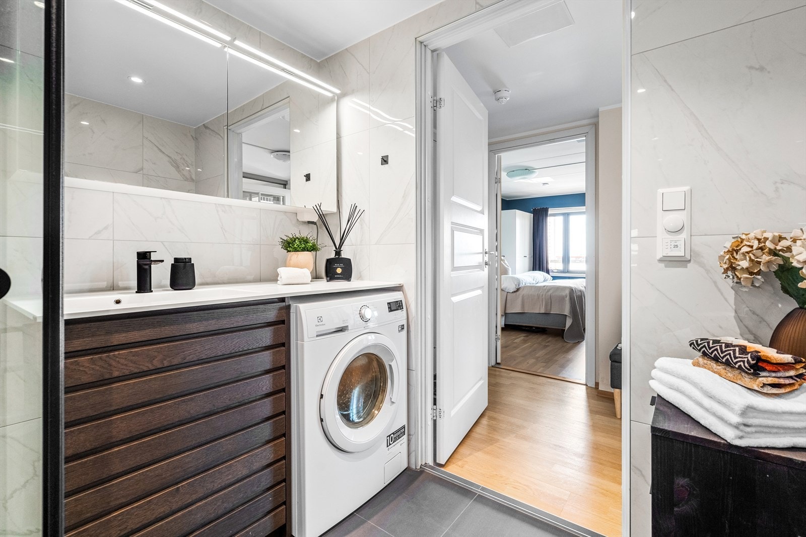 Badet er utstyrt med baderomsinnredning med skap, Kuma Rector servant/plate og ett-greps blandebatteri, veggmontert toalett og dusjhjørne Galleribilde