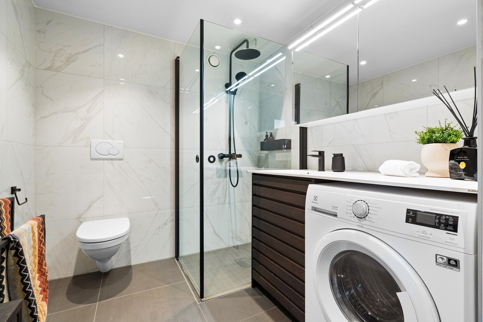 Badet har behagelig gulvvarme, downlights i himling og opplegg for vaskemaskin Galleribilde