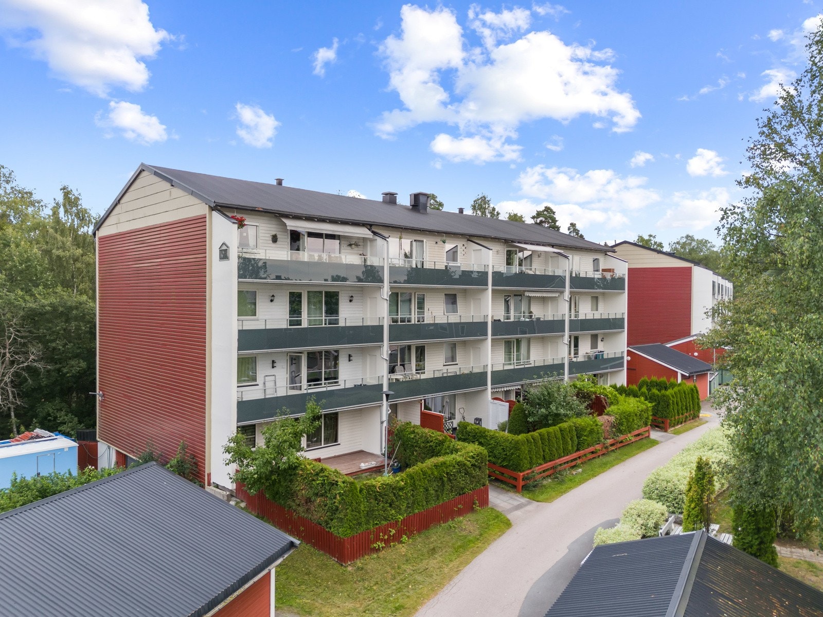 Fellestomten er pent opparbeidet med gressplen, prydbusker og asfalterte internveier. Galleribilde