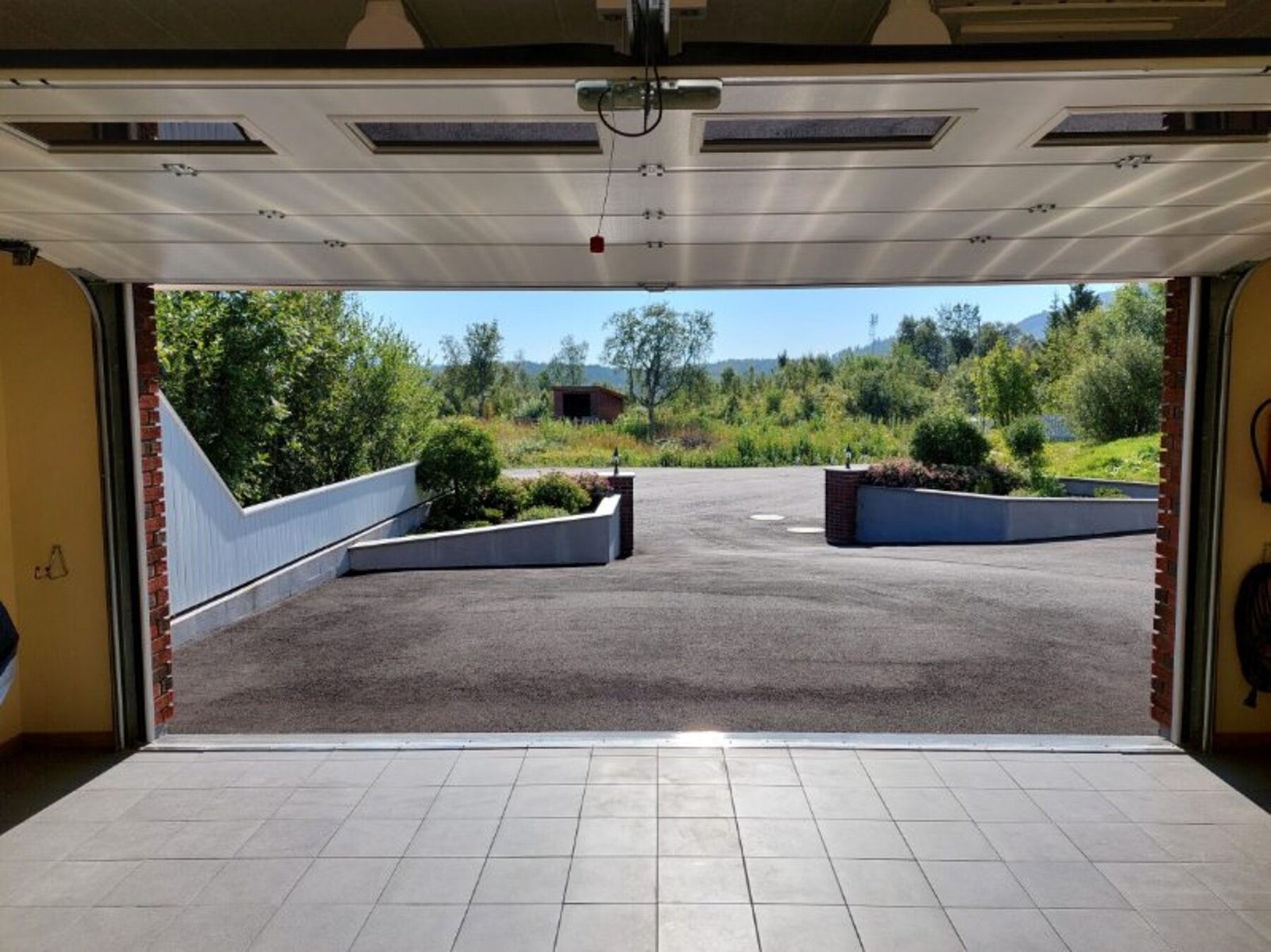 Elektrisk portåpner og flislagt gulv i garasjen.
Utebod. (Bilde tatt av selger) Galleribilde