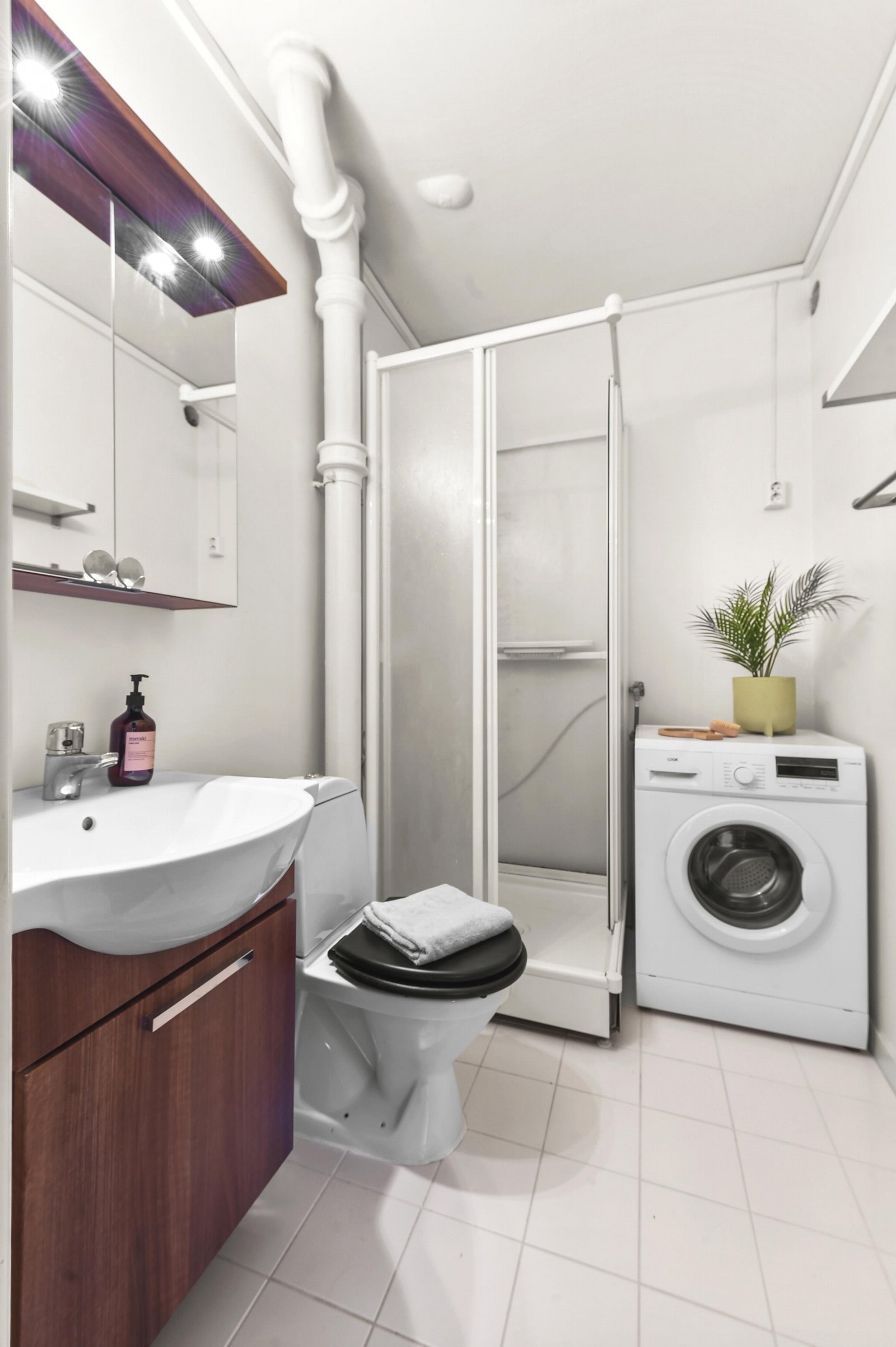 Bad innredet med dusjkabinett, servant med underskap, wc og speilskap. Galleribilde