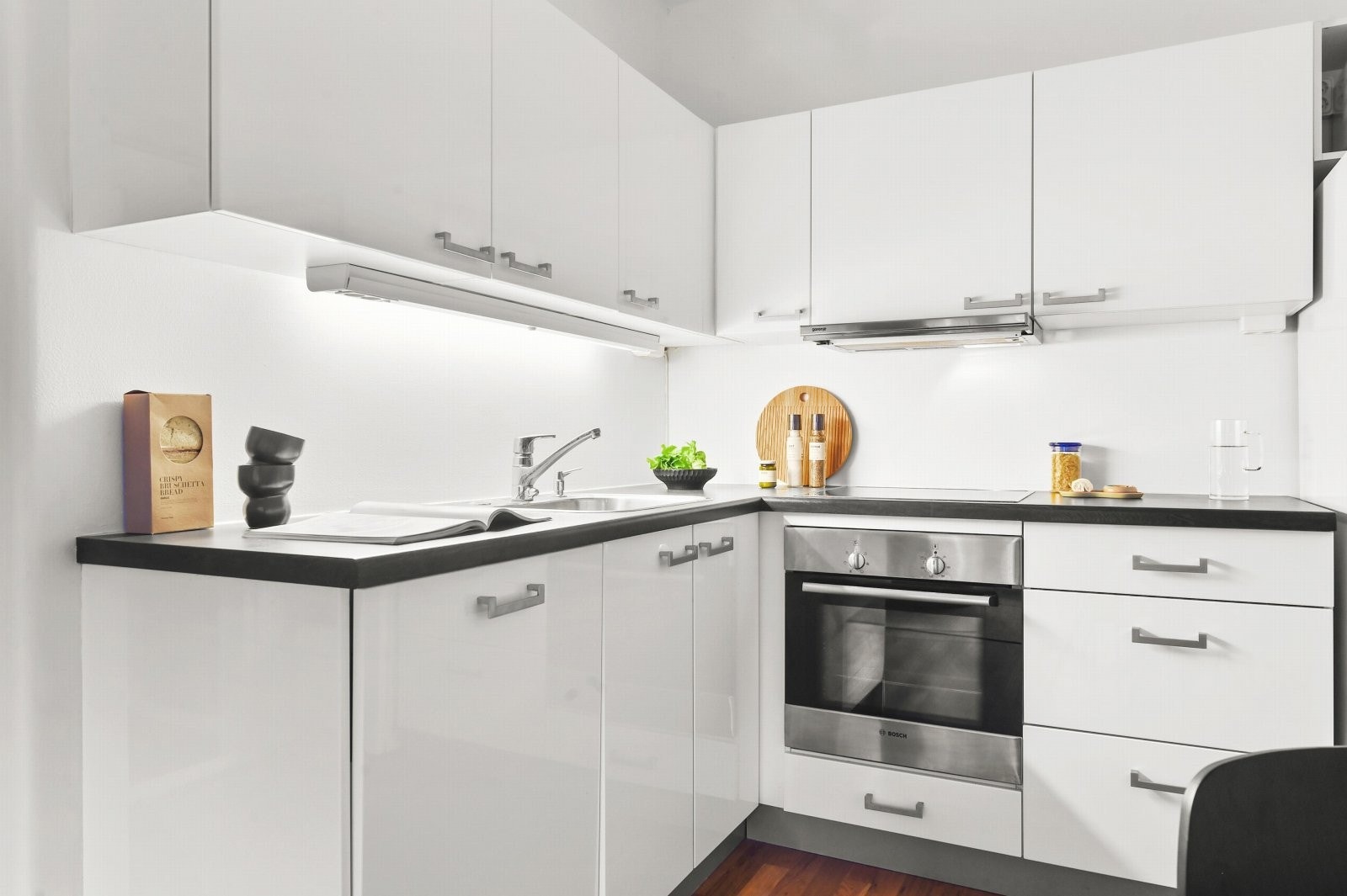 Stilren kjøkkeninnredning med slette fronter og laminat benkeplate. Galleribilde