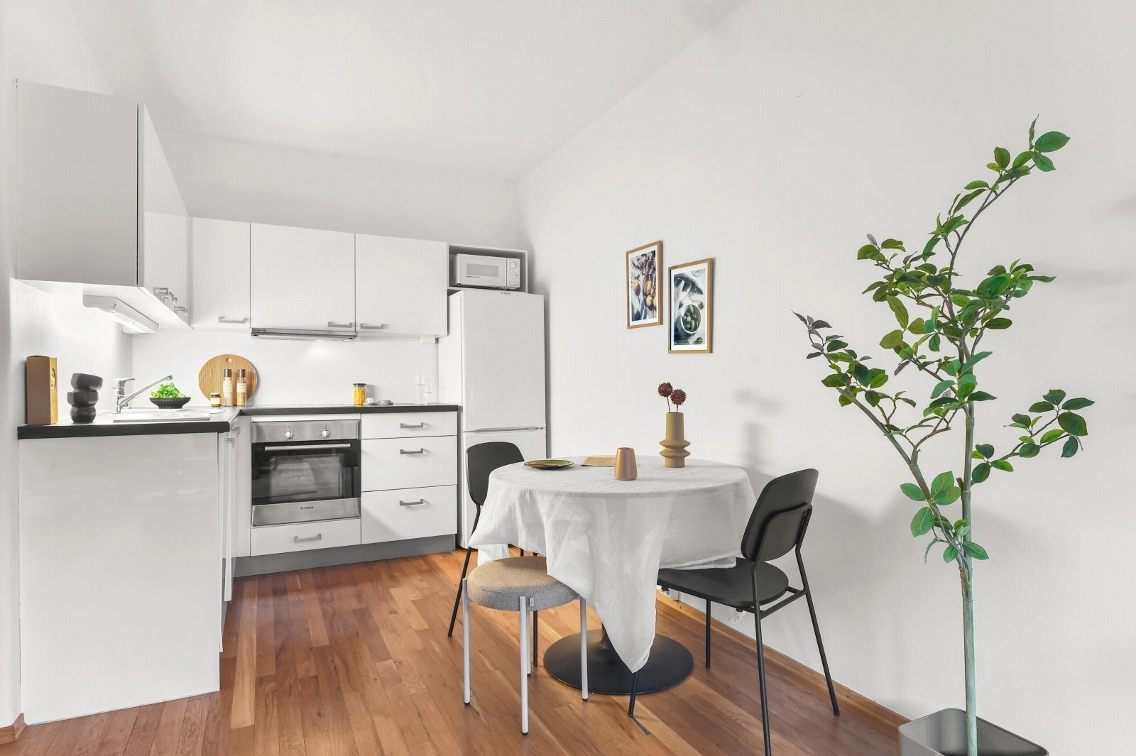 Plass til spisegruppe som danner et naturlig skille mellom kjøkken og stuedel. Galleribilde