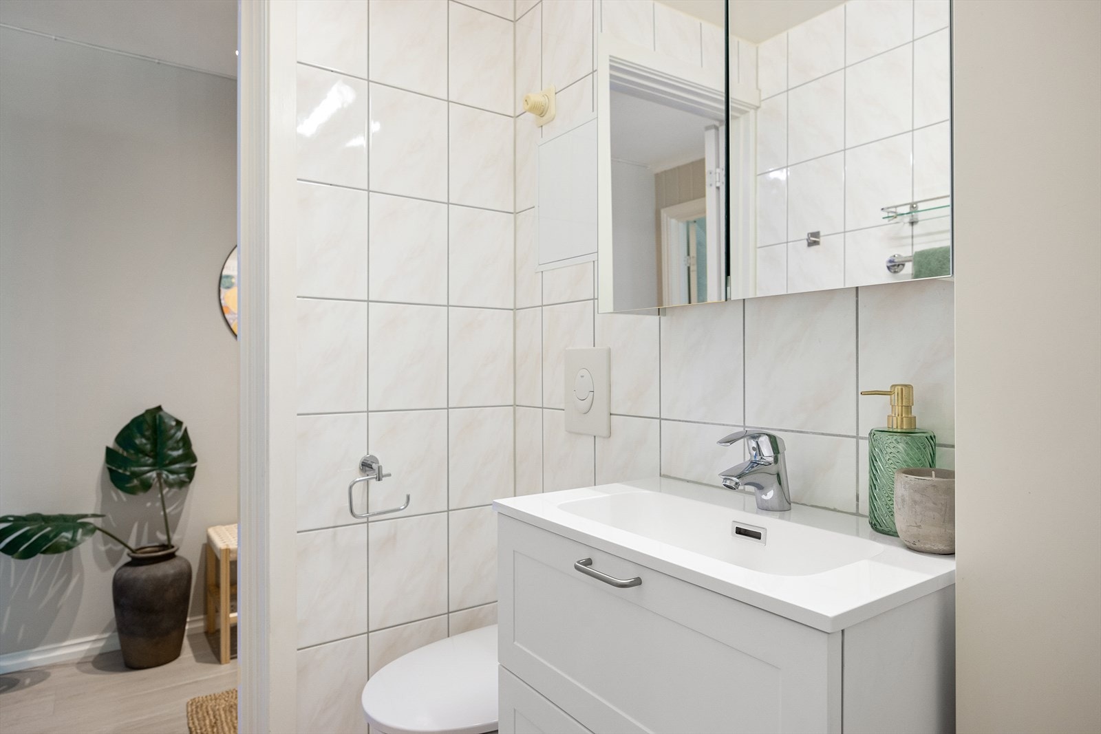 Badet består av servantskap med nedfelt servant (ny i 2024), veggskap med speildører og lys over, samt vegghengt klosett med innebygd sisterne. Videre er det en dusjsone med innfelte dusjdører i herdet glass. Galleribilde