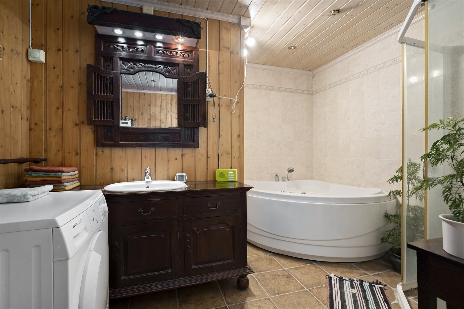 Badet har plass til både dusj, badekar og opplegg til vaskemaskin. I tillegg er det servant i stor innredning og toaltt. Varmekabler i gulv. Spotter i taket fungerer ikke iflg eier. Galleribilde
