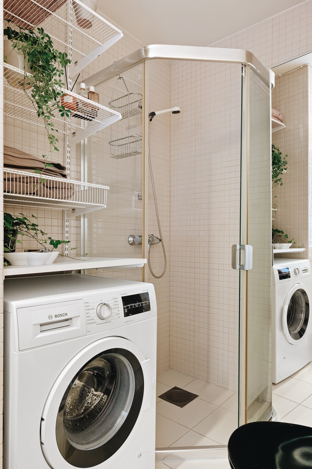 Badet inneholder toalett, helstøpt servant, dusjdører i klart glass og opplegg for vaskemaskin. Galleribilde