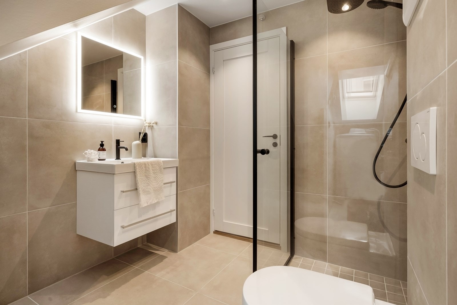 Badet står i stil med resten av boligen og er lekkert helfliset. Galleribilde