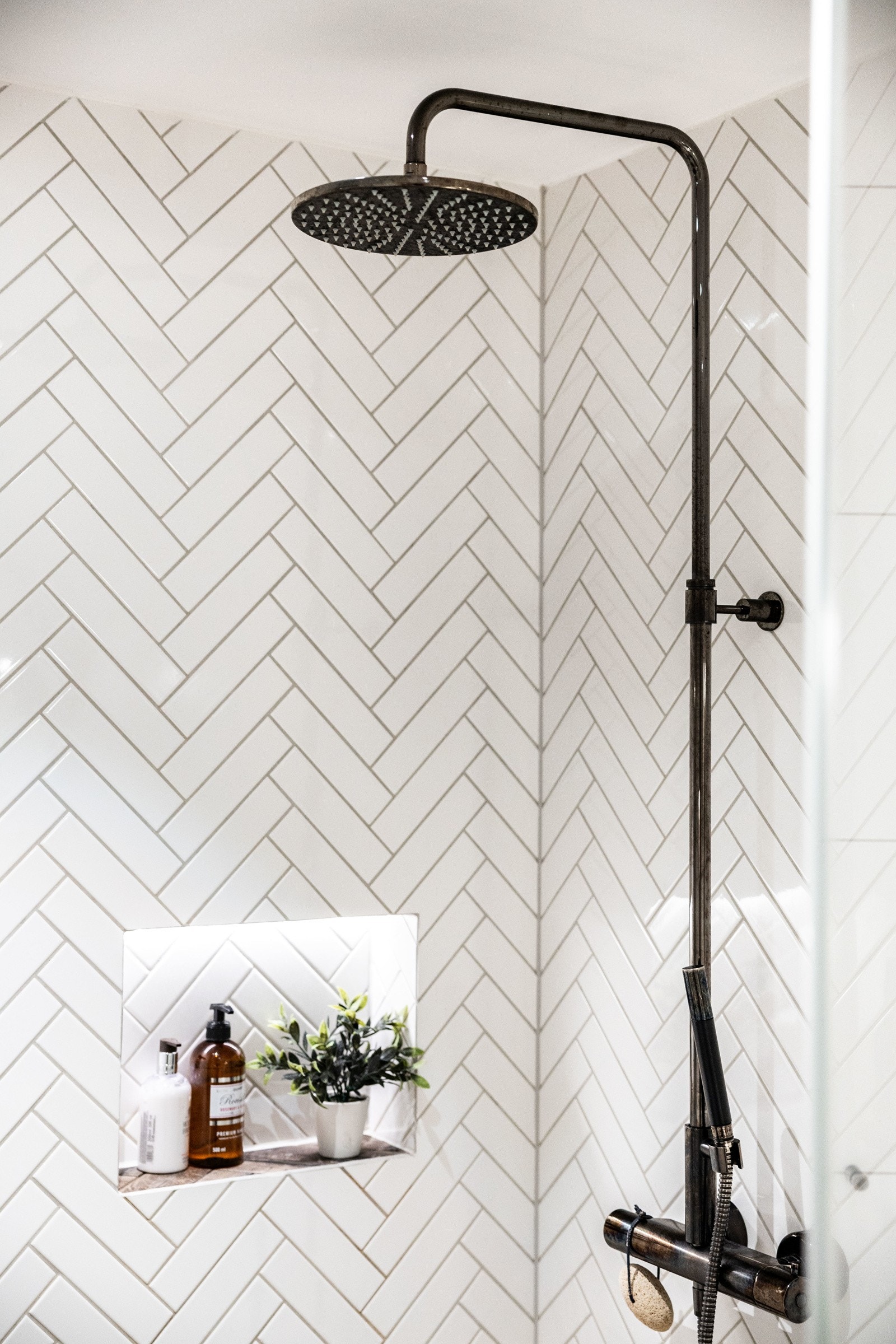 Dusjsonen er praktisk utformet med innfellbare glassdører og en dusjløsning som inkluderer både hånddusj og regndusj med to-greps armatur. Galleribilde