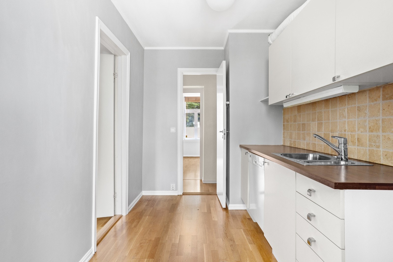 Kjøkken med lyse fronter og opplegg for oppvaskmaskin. Galleribilde