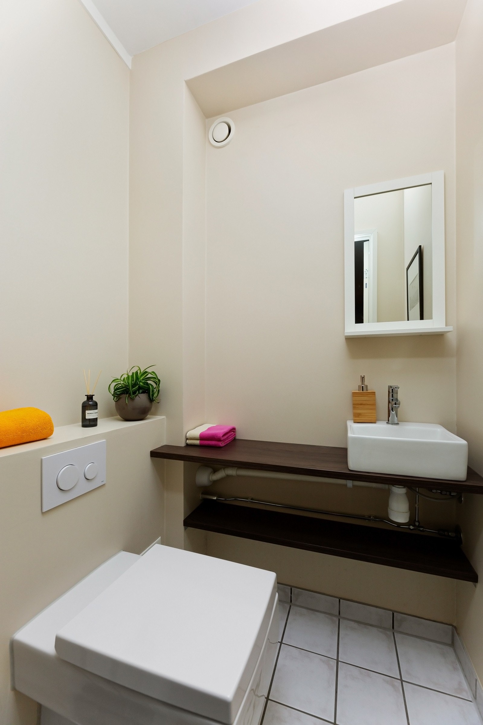 Vegg i vegg med badet har boligen separat wc med veggehengt toalett og servant med innredning og speil. Galleribilde