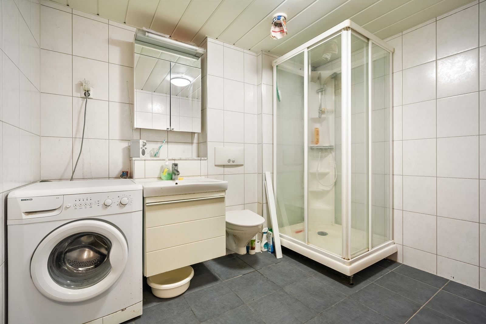 Badet inneholder: Vegghengt toalett, helstøpt servant, dusjkabinett, opplegg for vaskemaskin. Varmekabler i gulv. Galleribilde