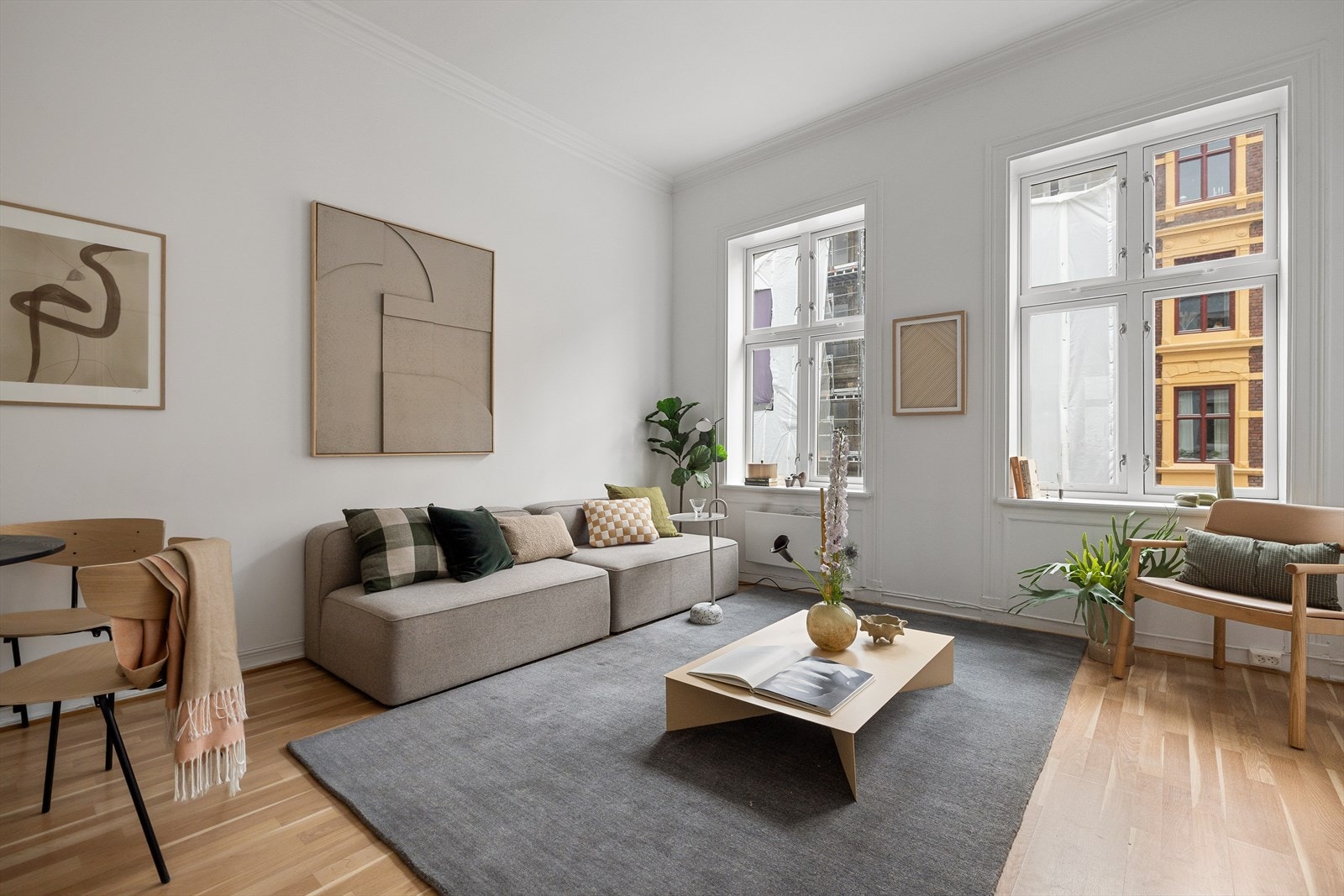 Stuen i leiligheten er romslig og flott opplyst med store vindusflater som gir rikelig med naturlig lys, og skaper en god atmosfære Galleribilde