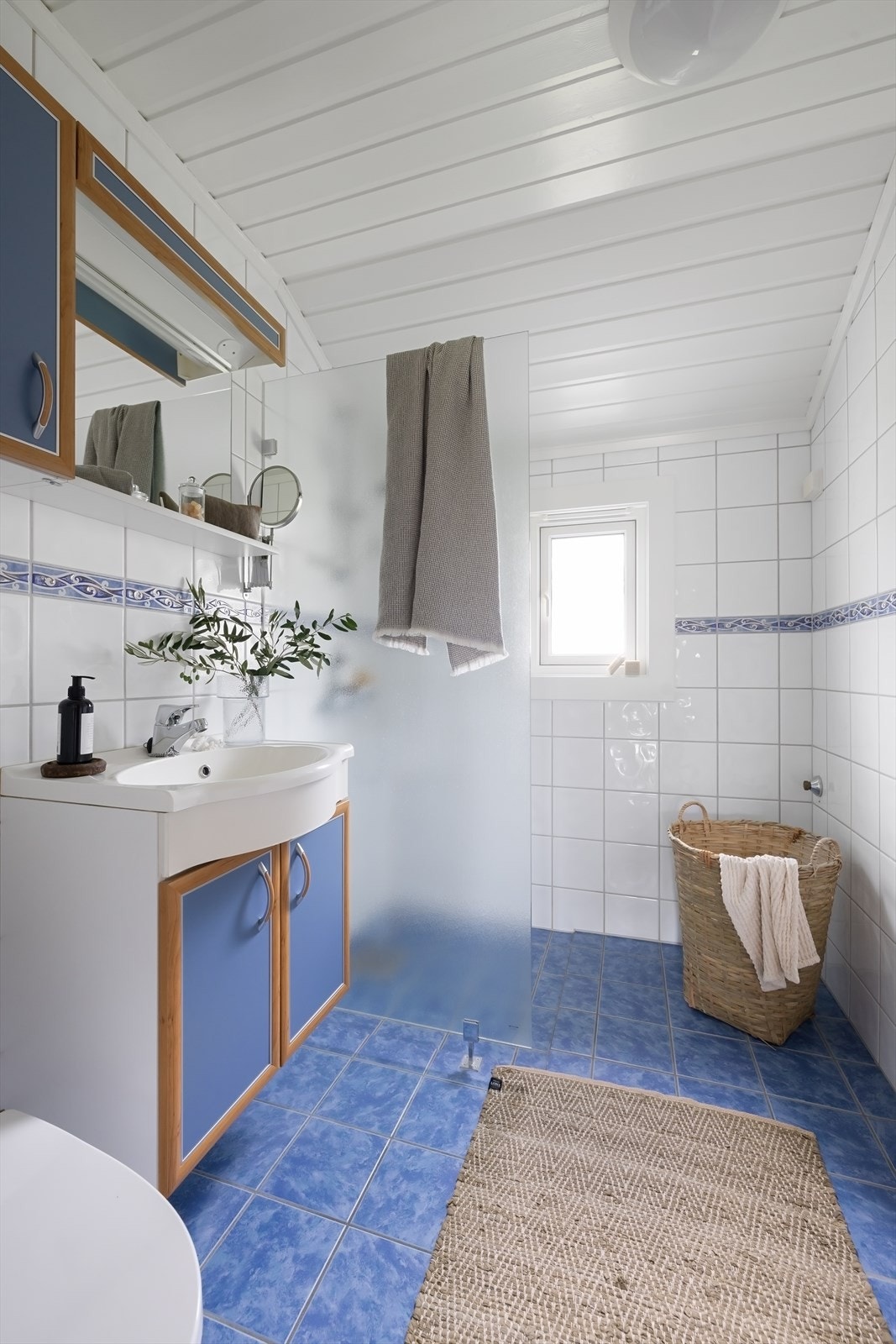 Videre har badet dusjhjørne med to-greps dusjarmatur og gulvstående toalett Galleribilde