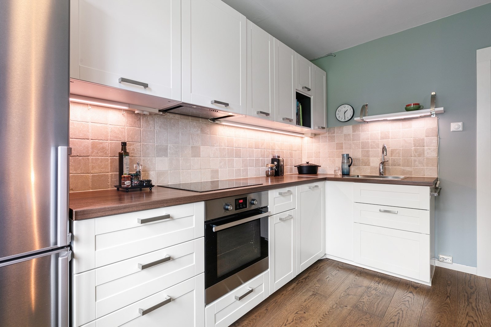 Innredning fremstår med profilerte fronter og laminert benkeplate. Det er flislagt mellom benkeplate og overskap for ekstra beskyttelse av overflater. Galleribilde