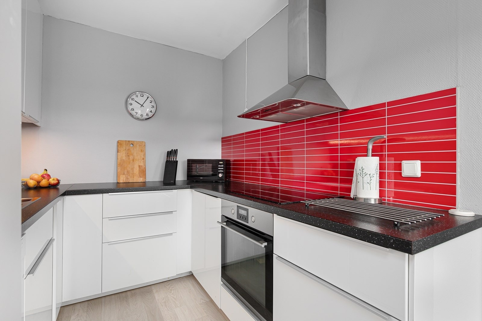 IKEA kjøkkeninnredning fra 2016 med hvite høyglans laminerte fronter og sorte laminerte benkeplater. Galleribilde