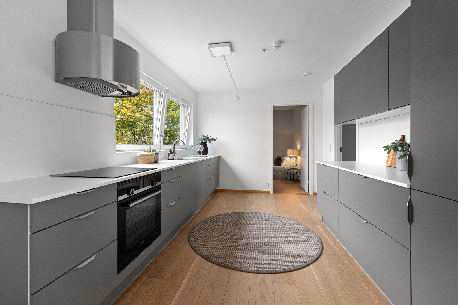 Tidsriktig glatt innredning, soft close, laminat benkeplate med nedfelt induksjonstopp og planlimt kum, integrert komfyr, oppvaskmaskin, kjøl/frys. Galleribilde