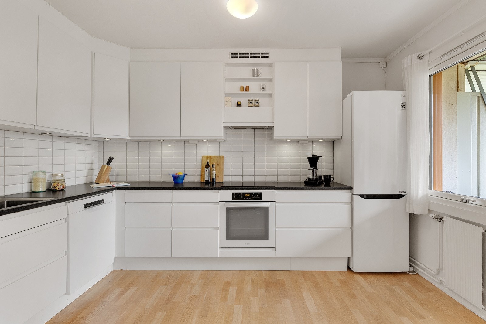 Kjøkkenet er fra 2010 med glatte fronter og laminert benkeplate med integrert kjøkkenkum. Galleribilde