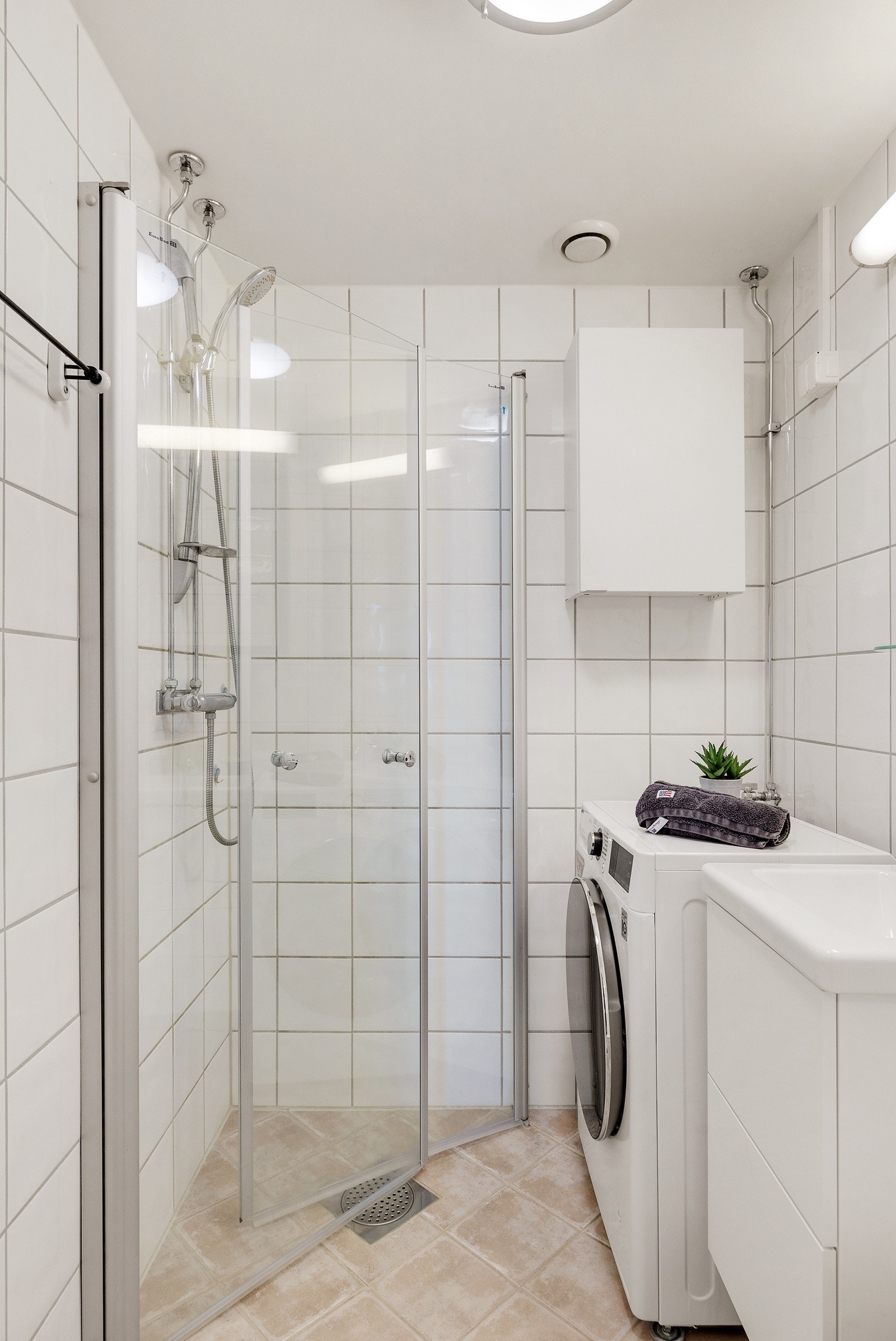 Badet har fliser på vegger og gulv, og god belysning. Galleribilde