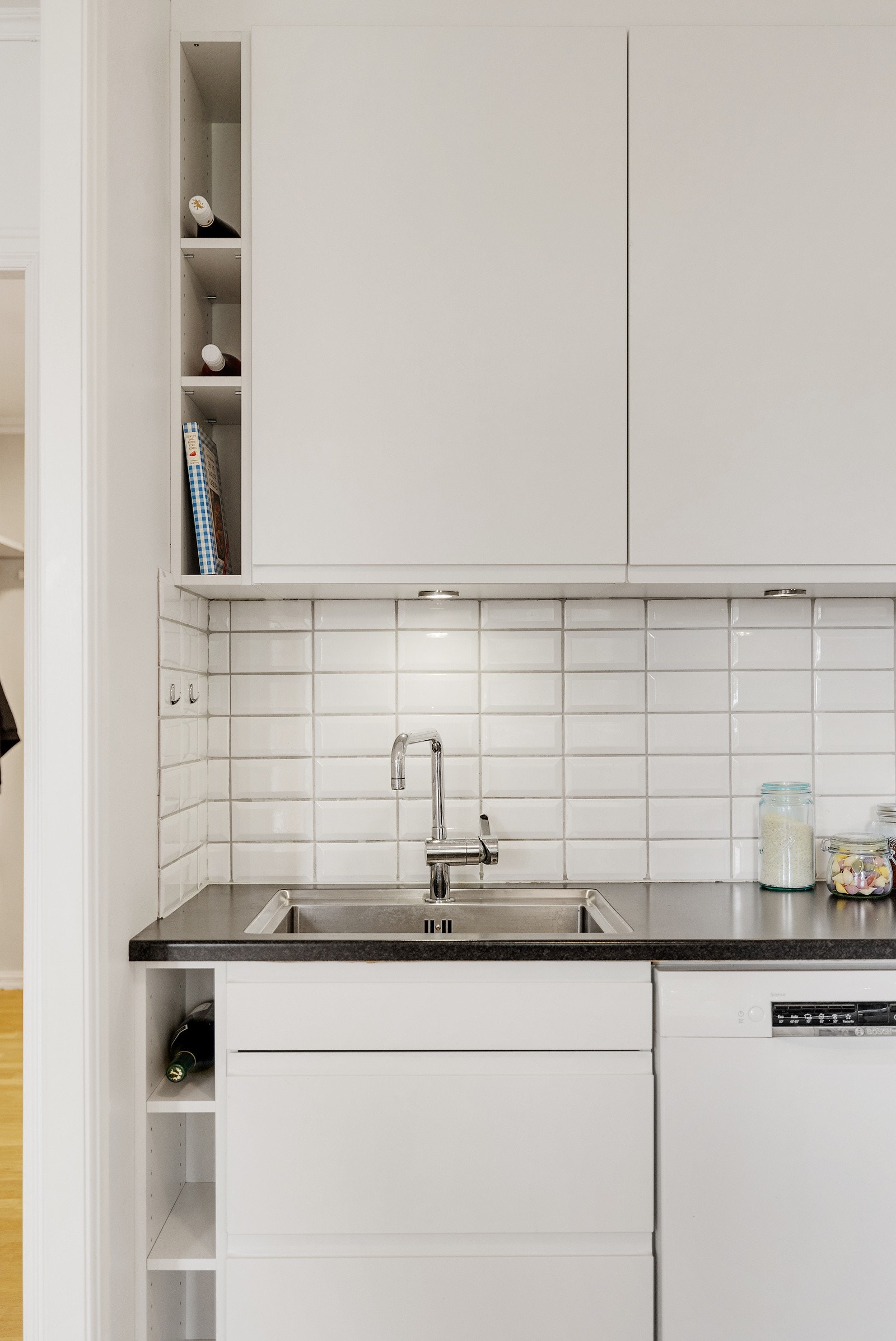 Det er flislagt vegg over kjøkkenbenk og kjøkkenventilator med kullfilter. Galleribilde